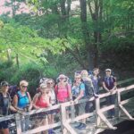 A smiling group of hikers posing on a wooden bridge